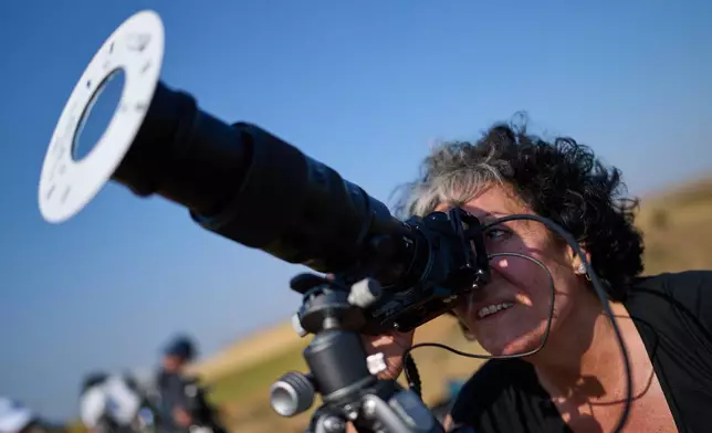 Mara Estepa, a member of the "Los Taraos" amateur astrophotography group, sets up her camera to shoot a total solar eclipse in Berlanga de Duero, central Spain, Wednesday, Aug. 12, 2026. (AP Photo/Bernat Armangue)