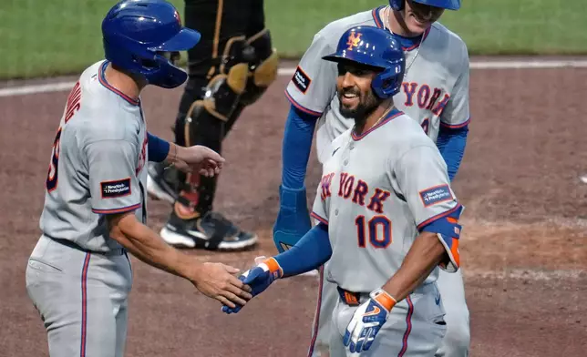 New York Mets' Marcus Semien (10) celebrates with Jared Young, left, and Carson Benge, back right, after hitting a three-run home run off Pittsburgh Pirates pitcher Carmen Mlodzinski during the third inning of a baseball game in Pittsburgh, Friday, Aug. 7, 2026. (AP Photo/Gene J. Puskar)