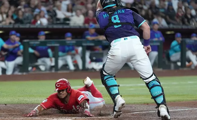 Cincinnati Reds' Dane Myers, left, scores a run as Arizona Diamondbacks catcher James McCann (8) gets a late throw during the third inning of a baseball game, Sunday, Aug. 23, 2026, in Phoenix. (AP Photo/Ross D. Franklin)