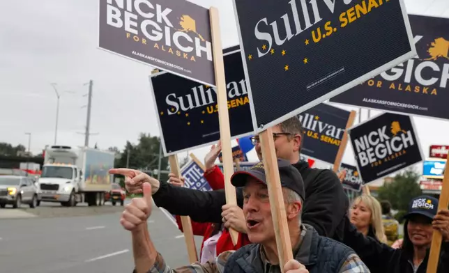 Sen. Dan Sullivan, R-Alaska, who is seeking a third term, flashes a thumbs up after a passing motorist honked during a sign waving event at an intersection on primary election day in Anchorage, Alaska, Tuesday, Aug. 18, 2026. (AP Photo/Mark Thiessen)
