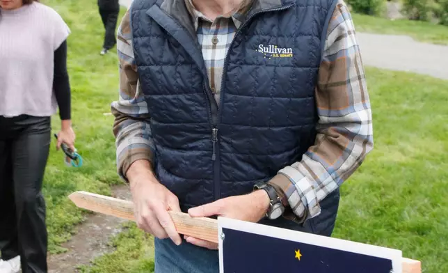 Sen. Dan Sullivan, R-Alaska, arrives to wave signs at an intersection during morning rush hour in Anchorage, Alaska, Tuesday, Aug. 18, 2026. (AP Photo/Mark Thiessen)