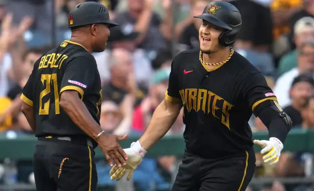 Pittsburgh Pirates' Rafael Flores Jr., right, is greeted by third base coach Tony Beasley as he rounds third base after hitting a solo home run off Boston Red Sox pitcher Jake Bennett during the second inning of a baseball game in Pittsburgh, Friday, Aug. 14, 2026. (AP Photo/Gene J. Puskar)