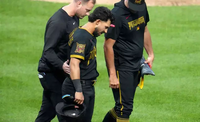 Pittsburgh Pirates' Nick Gonzales, center, walks to first base with manger Don Kelly, right, and a team trainer, after being hit by a pitch from Boston Red Sox pitcher Jovani Morán during the fifth inning of a baseball game in Pittsburgh, Friday, Aug. 14, 2026. (AP Photo/Gene J. Puskar)