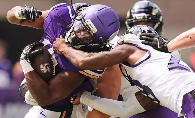Minnesota Vikings running back Jermar Jefferson, left, is tackled by Baltimore Ravens cornerback Marquise Robinson, right, during the second half of an NFL preseason football game, Saturday, Aug. 22, 2026, in Minneapolis. (AP Photo/Abbie Parr)
