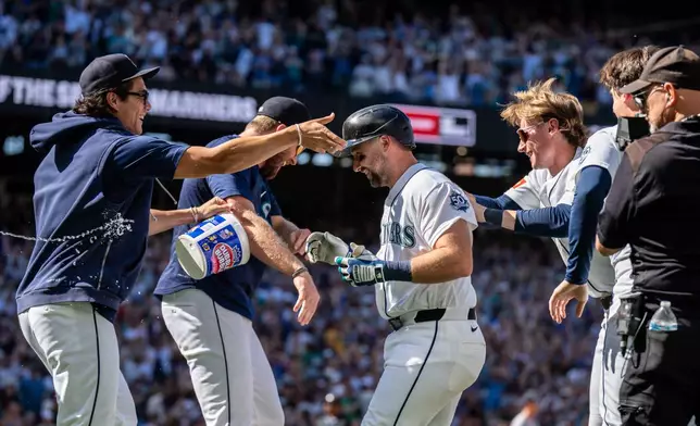 Seattle Mariners, including, Bryan Woo, left, Cal Raleigh, center, and Colt Emerson, third from right, celebrate after a baseball game against the Minnesota Twins, Saturday, Aug. 1, 2026, in Seattle. (AP Photo/Stephen Brashear)