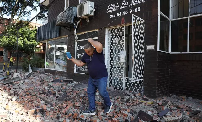 A man leaves an apartment building after an earthquake struck Cali, Colombia, Monday, Aug. 10, 2026. (AP Photo/Santiago Saldarriaga)