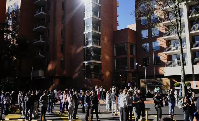 People stand outside their homes after a quake was felt in Bogota, Colombia, Monday, Aug. 10, 2026. (AP Photo/Ivan Valencia)