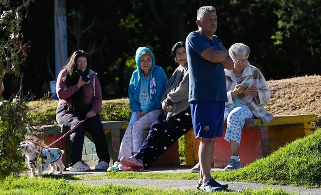 People stand outside their homes after a quake was felt in Bogota, Colombia, Monday, Aug. 10, 2026. (AP Photo/Fernando Vergara)