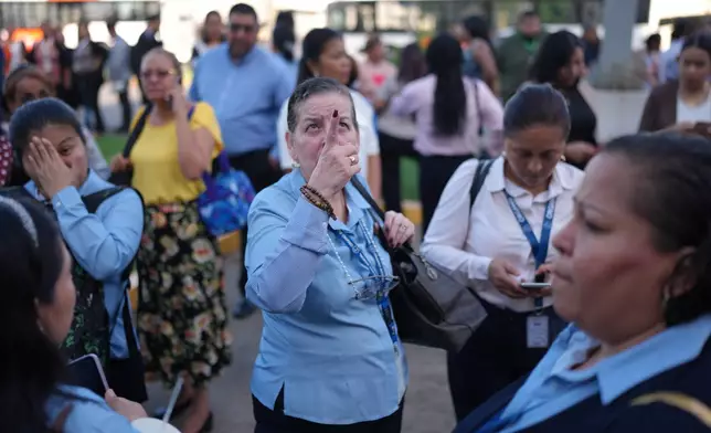 Government workers stand outside their office buildings in Panama City, Monday, Aug. 10, 2026, after feeling an earthquake with an epicenter in neighboring Colombia. (AP Photo/Matias Delacroix)