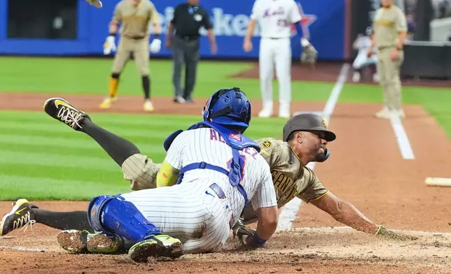 New York Mets catcher Francisco Alvarez (4) tags out San Diego Padres' Xander Bogaerts at home plate during the second inning of a baseball game Monday, Aug. 17, 2026, in New York. (AP Photo/Frank Franklin II)