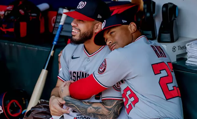 Washington Nationals first baseman Luis García Jr., left, is hugged in the dugout by first base coach Corey Ray (23) after he was scratched from the starting lineup before a baseball game against the Atlanta Braves, Sunday, Aug. 2, 2026, in Atlanta. (AP Photo/Erik S. Lesser)