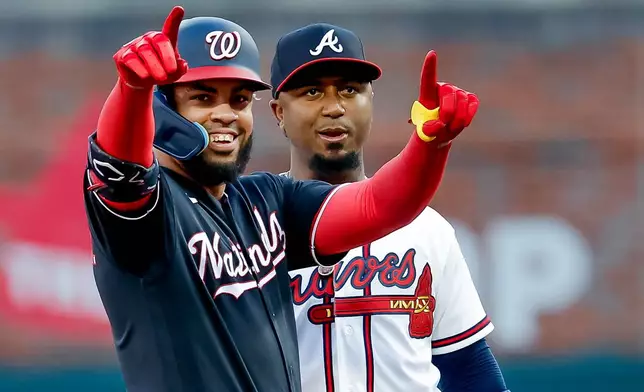 Washington Nationals first baseman Luis García Jr., left, reacts after hitting a double as Atlanta Braves second baseman Ozzie Albies looks on during the first inning of a baseball game, Thursday, July 30, 2026, in Atlanta. (AP Photo/Erik S. Lesser)