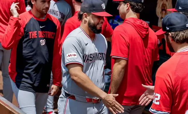 Washington Nationals first baseman Luis García Jr., center, greets teammates in the dugout after he was scratched from the starting lineup before a baseball game against the Atlanta Braves, Sunday, Aug. 2, 2026, in Atlanta. (AP Photo/Erik S. Lesser)