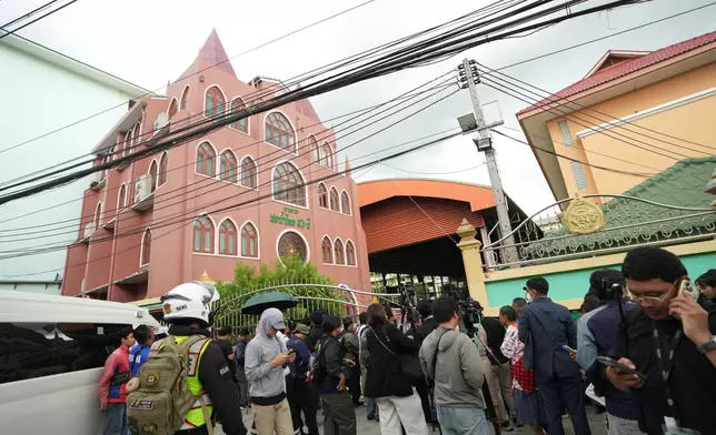 A crowd gathers outside a school where deaths and injuries were reported after a shooting in Thailand's Nonthaburi province, Friday, Aug. 7, 2026. (AP Photo/Sakchai Lalit)