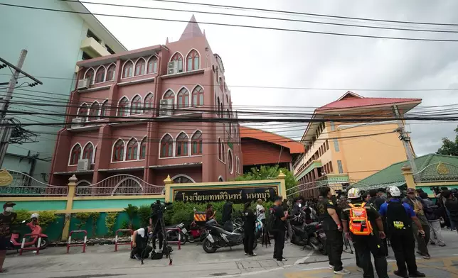 People gather outside after a shooting at the Debsirin Nonthaburi School in Thailand's Nonthaburi province, Friday, Aug. 7, 2026. (AP Photo/Sakchai Lalit)
