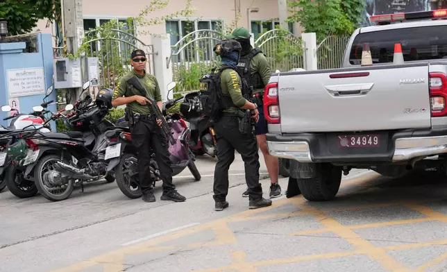Police stand guard after a shooting at the Debsirin Nonthaburi School in Thailand's Nonthaburi province, Friday, Aug. 7, 2026. (AP Photo/Sakchai Lalit)