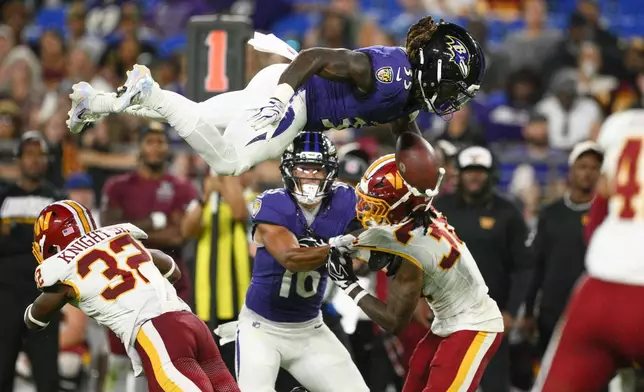 Baltimore Ravens running back Johnathan Ward (35) dives over Washington Commanders defensive back Qwuantrezz Knight Sr. (32) during the second half of an NFL preseason football game, Friday, Aug. 28, 2026, in Baltimore. (AP Photo/Nick Wass)