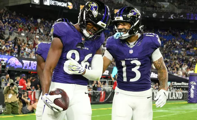 Baltimore Ravens wide receiver Cornelius Johnson (86) celebrates with Elijah Sarratt (13) after catching a touchdown pass against the Washington Commanders during the second half of an NFL preseason football game, Friday, Aug. 28, 2026, in Baltimore. (AP Photo/Nick Wass)