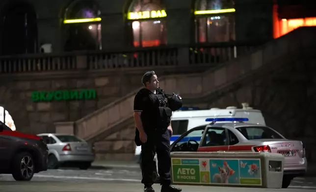 A policeman stands near the site where an improvised explosive device detonated at a restaurant in central Moscow, Saturday, Aug. 1, 2026. (AP Photo/Pavel Bednyakov)