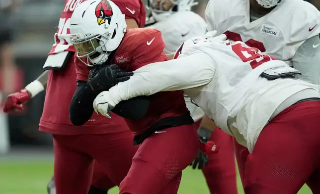Arizona Cardinals running back Jeremiyah Love, left, is stopped by Cardinals defensive lineman Andrew Billings during practice at the NFL football team's training camp, Wednesday, July 29, 2026, in Glendale, Ariz. (AP Photo/Ross D. Franklin)