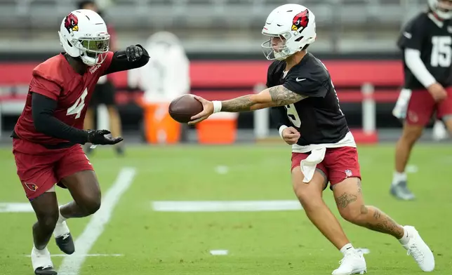 Arizona Cardinals quarterback Carson Beck, right, hands the ball off to Cardinals running back Jeremiyah Love during NFL football training camp practice, Thursday, July 23, 2026, in Glendale, Ariz. (AP Photo/Ross D. Franklin)