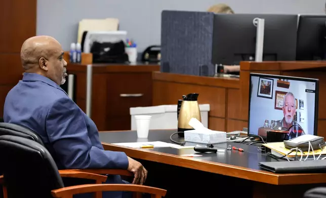 Duane Davis listens as Brent Becker, a retired Las Vegas Metro Police Department homicide detective, testifies by video feed during his murder trial, related to the 1996 killing of rapper Tupac Shakur, at Clark County District Court Regional Justice Center, Monday, Aug. 17, 2026, in Las Vegas. (Steve Marcus/Pool Photo via AP)