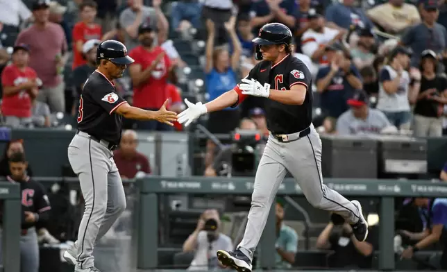 Cleveland Guardians third base coach Rouglas Odor, left, celebrates with Petey Halpin, right, as Halpin rounds the bases on a solo home run in the third inning of a baseball game against the Colorado Rockies, Friday, Aug. 21, 2026, in Denver. (AP Photo/Geneva Heffernan)