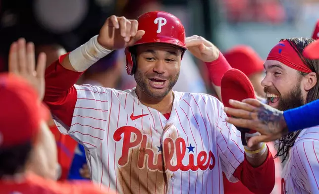 Philadelphia Phillies' Justin Crawford, center, celebrates with teammates after scoring during the third inning of a baseball game against the Miami Marlins, Monday, Aug. 17, 2026, in Philadelphia. (AP Photo/Chris Szagola)