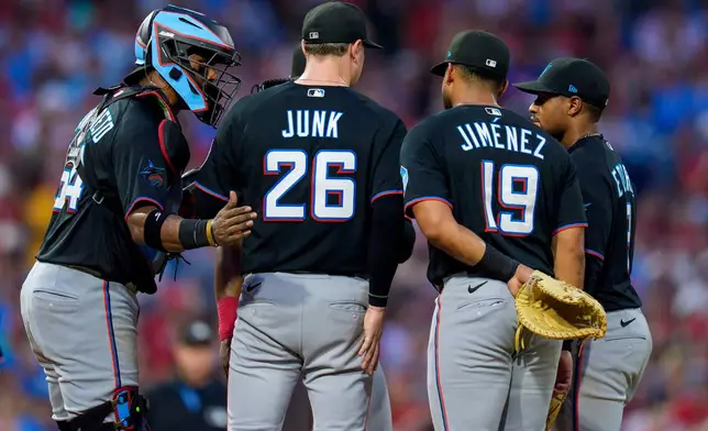 Miami Marlins starting pitcher Janson Junk (26) talks with catcher Brian Navarreto, left, first baseman Leonardo Jimenez (19) and second baseman Xavier Edwards, right, during the third inning of a baseball game against the Philadelphia Phillies, Monday, Aug. 17, 2026, in Philadelphia. (AP Photo/Chris Szagola)