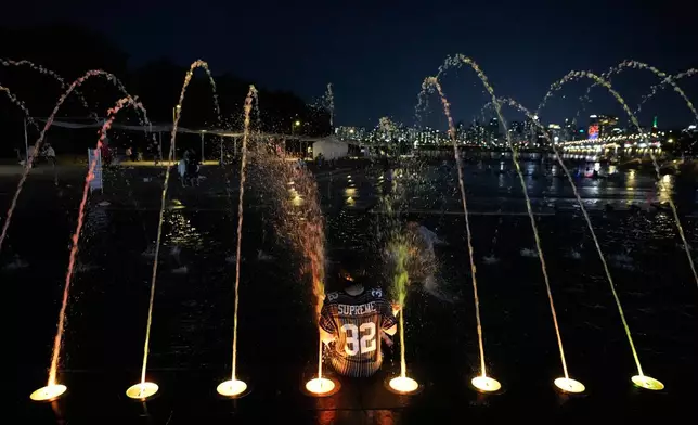 A man cools off in a public fountain in Seoul, South Korea, Tuesday, Aug. 4, 2026. (AP Photo/Ahn Young-joon)