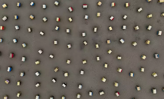 Empty beach chairs are pictured at the beach of the Baltic Sea in Travemuende, Germany, on a cool Tuesday morning, Aug. 4, 2026. (AP Photo/Michael Probst)