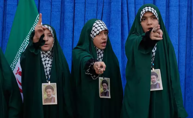 Iranian girls with portraits of the Supreme Leader Ayatollah Mojtaba Khamenei sing a song during Arbaeen rituals, which is held 40 days after Ashoura, commemorating the killing of the grandson of the Prophet Muhammad Imam Hussein and members of his family at the Battle of Karbala in 680 A.D. in Tehran, Iran, Tuesday, Aug. 4, 2026. (AP Photo/Vahid Salemi)