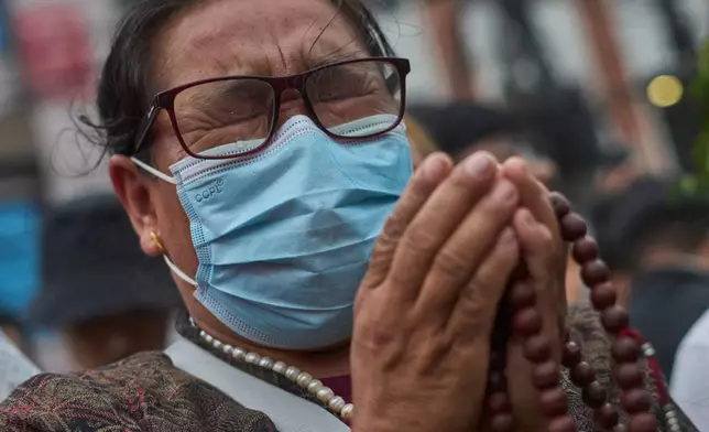 A family member sobs while observing movement of silence before lighting candles in memory of the climbers who died Thursday in an avalanche on Pakistan's Broad Peak, Kathmandu, Nepal, Tuesday, Aug. 4, 2026. (AP Photo/Niranjan Shrestha)