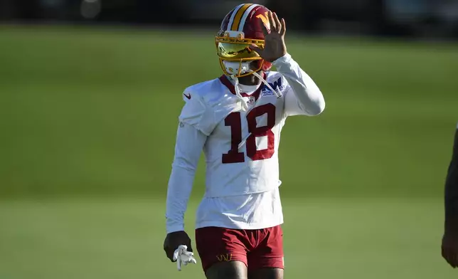 Washington Commanders wide receiver Stefon Diggs waves to fans at the team's NFL football training camp in Ashburn, Va., Friday, Aug. 7, 2026. (AP Photo/Nick Wass)