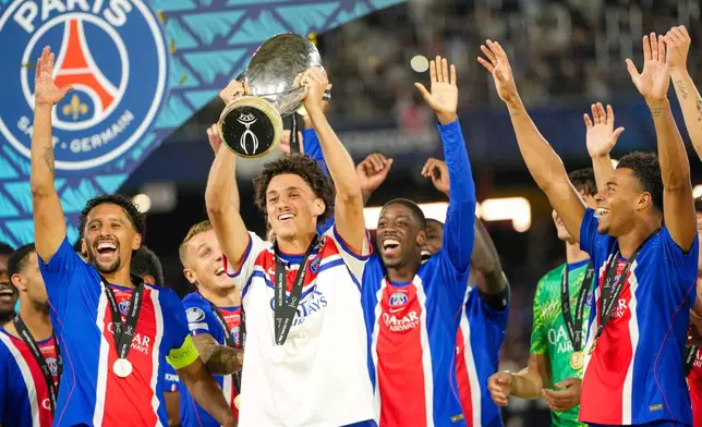 PSG's Maghnes Akliouche lifts the trophy during celebrations at the end of the UEFA Super Cup soccer match between Paris Saint-Germain and Aston Villa in Salzburg, Austria, Wednesday, Aug.12, 2026. (AP Photo/Darko Bandic)