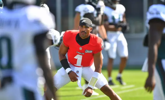 Philadelphia Eagles quarterback Jalen Hurts (1) warms up with teammates during a joint NFL football practice with the New England Patriots, Wednesday, Aug. 19, 2026, in Foxborough, Mass. (AP Photo/Steven Senne)
