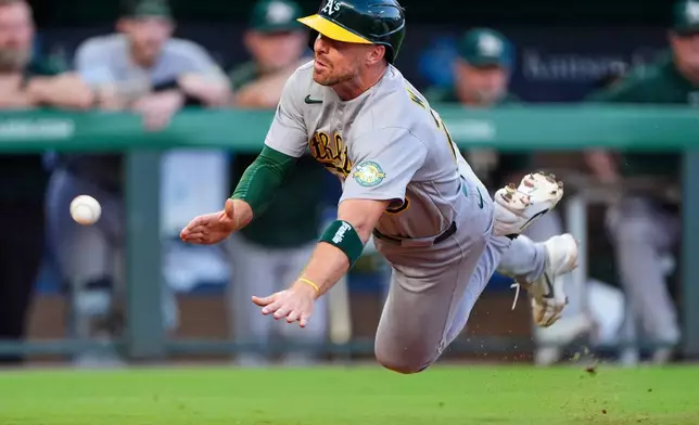 Athletics' Donovan Walton slides home to score on an RBI single hit by Henry Bolte during the fifth inning of a baseball game against the Kansas City Royals, Wednesday, Aug. 19, 2026, in Kansas City, Mo. (AP Photo/Charlie Riedel)