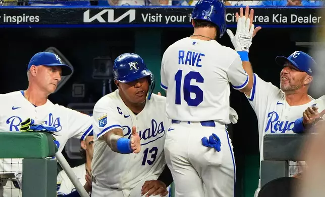 Kansas City Royals' John Rave (16) celebrates in the dugout after scoring on a single by Miakel Garcia during the eighth inning of a baseball game against the Athletics, Wednesday, Aug. 19, 2026, in Kansas City, Mo. (AP Photo/Charlie Riedel)