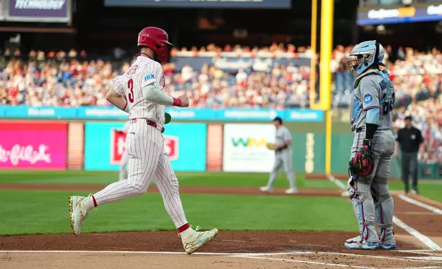 Philadelphia Phillies' Bryce Harper scoots past Miami Marlins catcher Brian Navarreto off of an RBI single by Phillies Alec Bohm during the first inning of a baseball game, Tuesday, Aug. 18, 2026, in Philadelphia. (AP Photo/Matt Rourke)