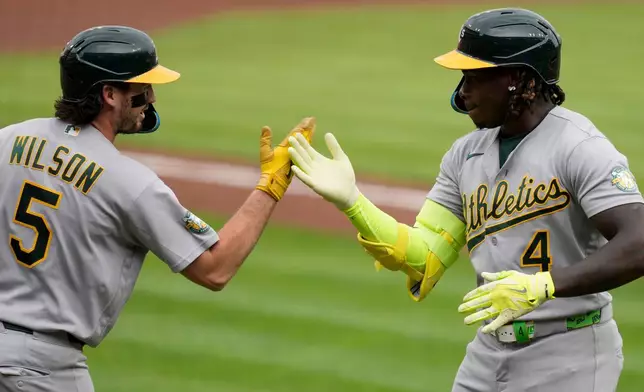 Athletics' Lawrence Butler (4) celebrates with Jacob Wilson (5) after Butler hit a solo home run during the first inning of a baseball game against the Cincinnati Reds in Cincinnati, Wednesday, Aug. 5, 2026. (AP Photo/Carolyn Kaster)