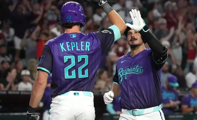 Arizona Diamondbacks' Nolan Arenado, right, celebrates with Max Kepler (22) after hitting a solo home run against the Los Angeles Dodgers in the second inning of a baseball game, Friday, Aug 7, 2026, in Phoenix. (AP Photo/Rick Scuteri)