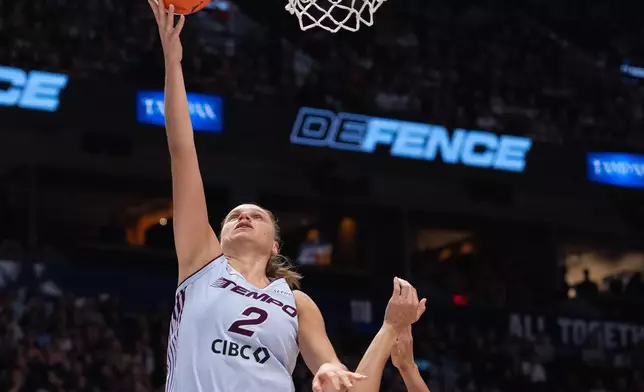 Toronto Tempo's Laura Juskaite (2) drives for a layup shot as Portland Fire's Teja Oblak (7) defends during the first half of a WNBA basketball game in Vancouver, British Columbia, Friday, Aug. 21, 2026. (Ethan Cairns/The Canadian Press via AP)