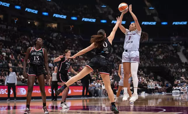 Toronto Tempo's Kiki Rice (1) shoots the ball as Portland Fire's Carla Leite (0) defends and Nyadiew Puoch (13) watches during the first half of a WNBA basketball game in Vancouver, British Columbia, Friday, Aug. 21, 2026. (Ethan Cairns/The Canadian Press via AP)