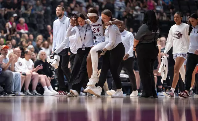 Toronto Tempo's Aneesah Morrow (24) is helped off the court during the first half of a WNBA basketball game against the Portland Fire in Vancouver, British Columbia, Friday, Aug. 21, 2026. (Ethan Cairns/The Canadian Press via AP)