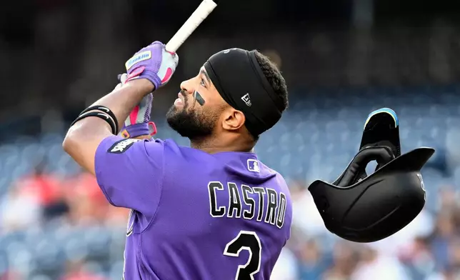 Colorado Rockies' Willi Castro looses his batting helmet as he hits a pop up to left field for an out during the first inning of a baseball game against the Washington Nationals, Wednesday, Aug. 26, 2026, in Washington. (AP Photo/John McDonnell)