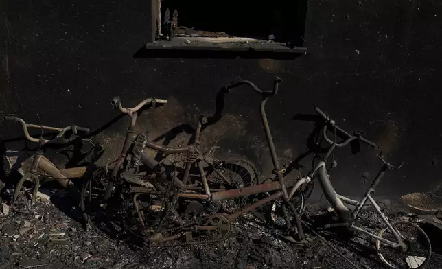 Burned bicycles lean against the wall of a house destroyed by a wildfire in Porto Germeno, northwest of Athens, Greece, Monday, Aug. 3, 2026. (AP Photo/Petros Giannakouris)