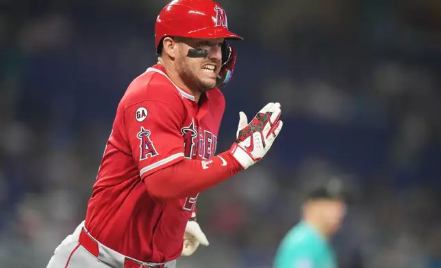 Los Angeles Angels' Mike Trout runs to reach first on a throwing error by Miami Marlins shortstop Otto Lopez during the third inning of a baseball game, Sunday, Aug. 9, 2026, in Miami. (AP Photo/Lynne Sladky)