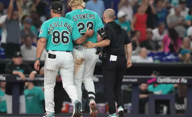 Miami Marlins' Kyle Stowers (28) is led off the field by manager Clayton McCullough (86) during the fifth inning of a baseball game against the Los Angeles Angels, Sunday, Aug. 9, 2026, in Miami. (AP Photo/Lynne Sladky)