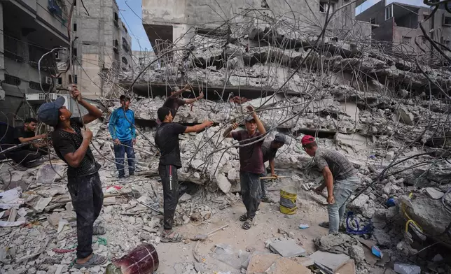 Palestinians remove iron from the rubble of buildings destroyed by Israeli airstrikes during the war with Hamas, repair and recycle it for construction, building tents or selling it, in Gaza City, Sunday, Aug. 16, 2026. (AP Photo/Jehad Alshrafi)