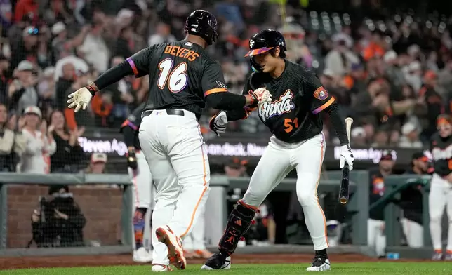 San Francisco Giants' Rafael Devers (16) is congratulated by teammate Jung Hoo Lee (51) after hitting a home run against the Cincinnati Reds during the fifth inning of a baseball game Tuesday, Aug. 25, 2026, in San Francisco. (AP Photo/Tony Avelar)